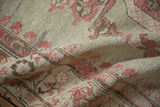 Distressed Kars carpet pile with mostly even wear, faded raspberry florals, and beige.
