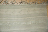 Raised woven elements and braided selvage of a distressed beige and blue Turkish Kilim.