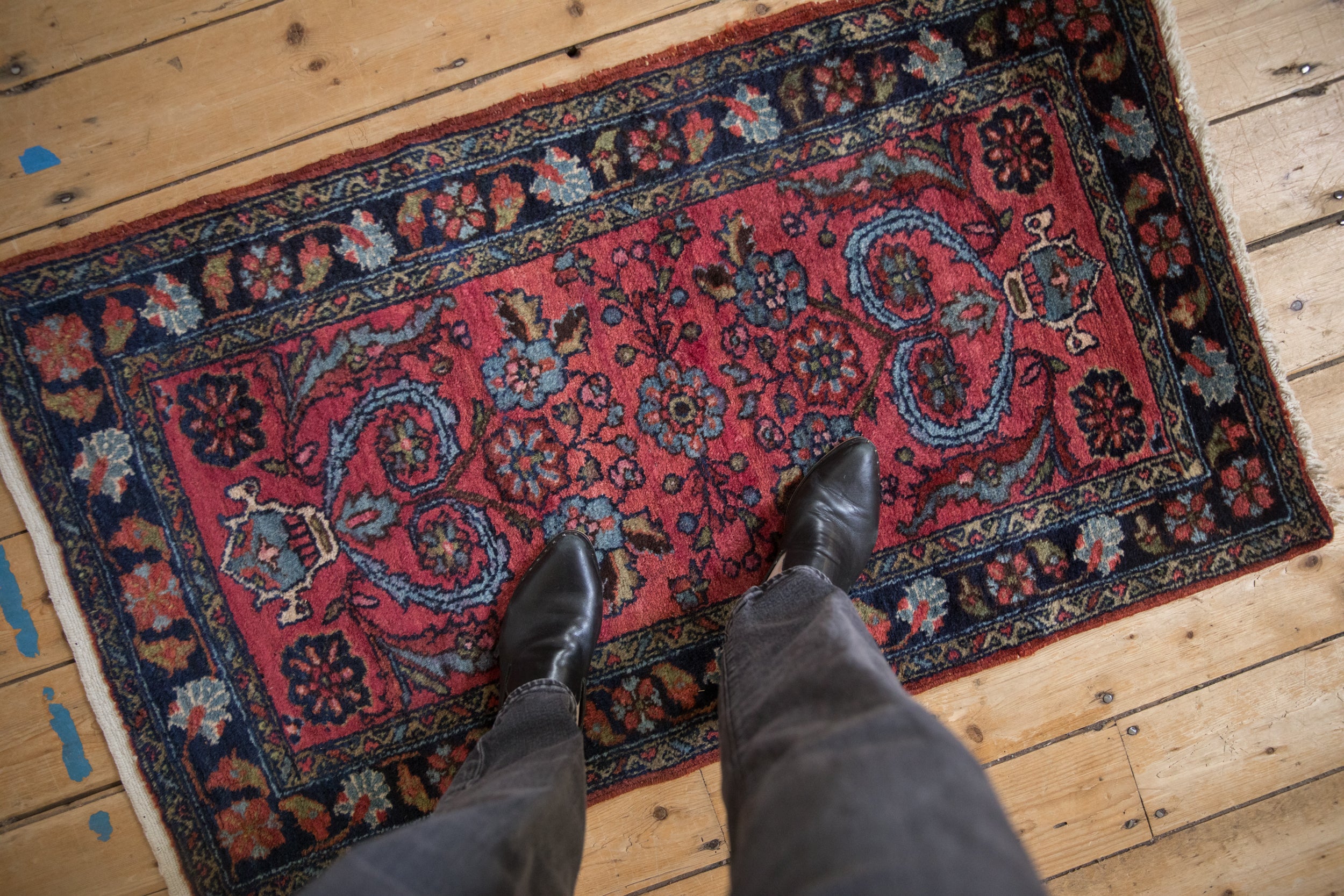 Vintage Mehreban rug's raspberry red field, blue floral tendrils, and navy Herati border.