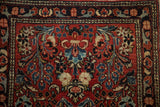 Ornate red field with expressive floral branches and pinwheel blossoms in navy, blue, ivory.