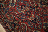 Vintage Persian Sarouk rug's textured pile, ornate floral details in deep red and blue.