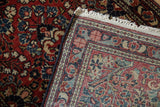 Vintage Sarouk rug's red floral pile, navy side cord, and patterned foundation.