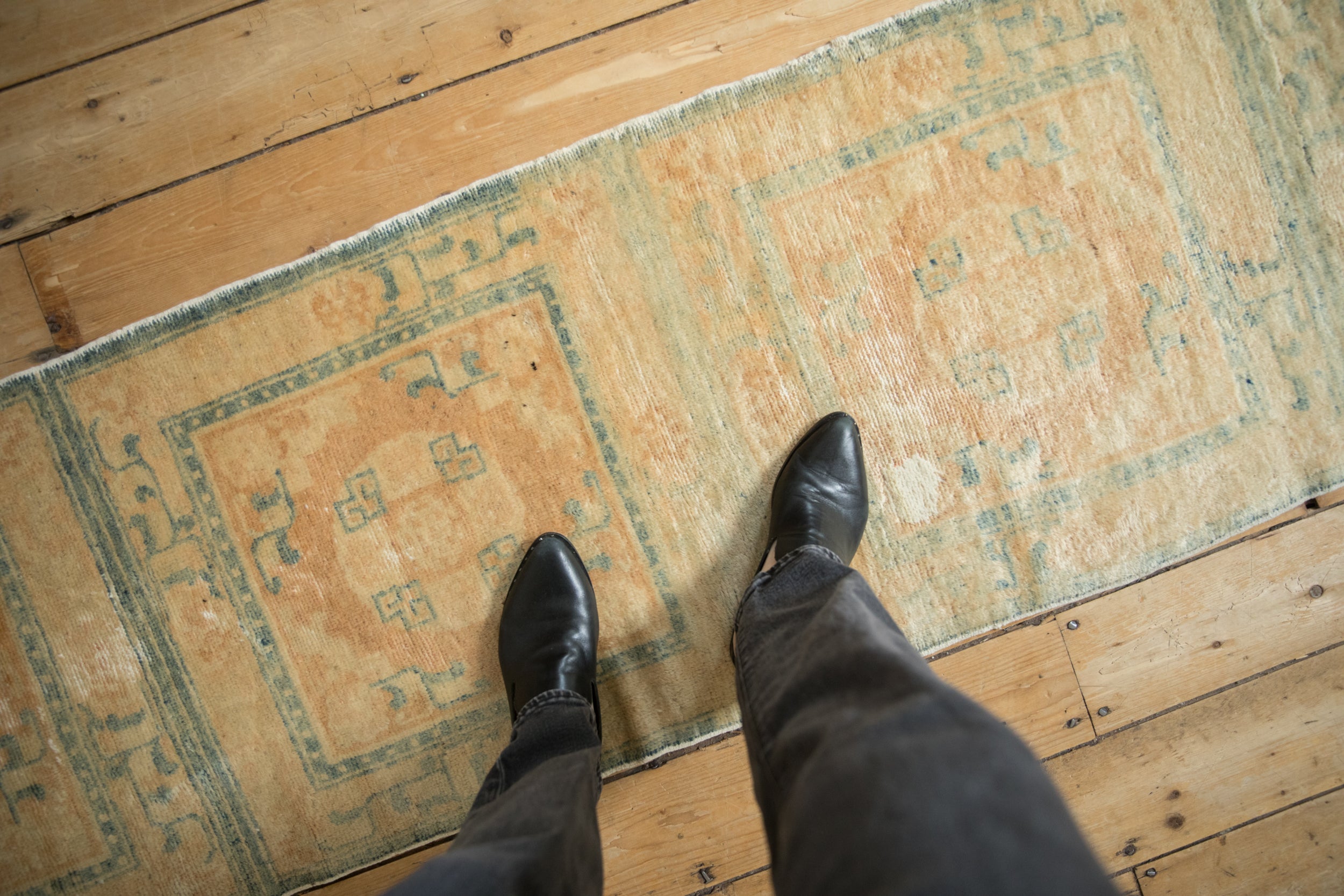 Distressed antique Peking runner, showcasing worn beige pile with geometric blue motifs.