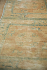 Visible knot heads and foundation on the distressed beige Peking runner's soft pile.