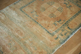 Distressed wool pile in soft beige and powder blue, revealing knot heads.