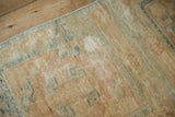 Aged texture and visible knot heads on a distressed beige and blue Peking runner.