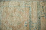 Distressed soft woolen pile of antique Peking runner, showing faded blue motifs.