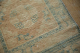 Distressed wool pile texture with faded powder blue stylized patterns on a beige antique Peking rug.