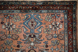 Vintage Mehreban rug corner, dusty copper floral field with blue and red vine borders.
