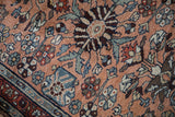Vintage Mehreban rug's dense floral blossoms, serrated leaves, and border in dusty copper, blue.