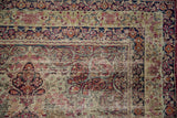 Antique Kerman rug corner, detailed millefleur field with scrolling vines and exposed foundation.