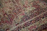 Antique Persian Kerman rug section, ivory, red, and navy thousand flower pattern with wear.