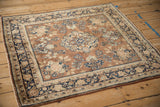 Sarouk rug corner detail showing chestnut brown field, floral bouquets, and navy palmette border.
