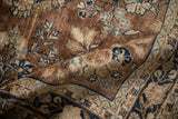 Floral bouquets, palmettes, and navy blue meandering vine border on the vintage Sarouk rug.
