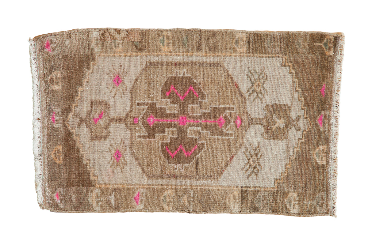Vintage distressed Kars rug with central geometric magenta motif, coffee brown, and even wear.