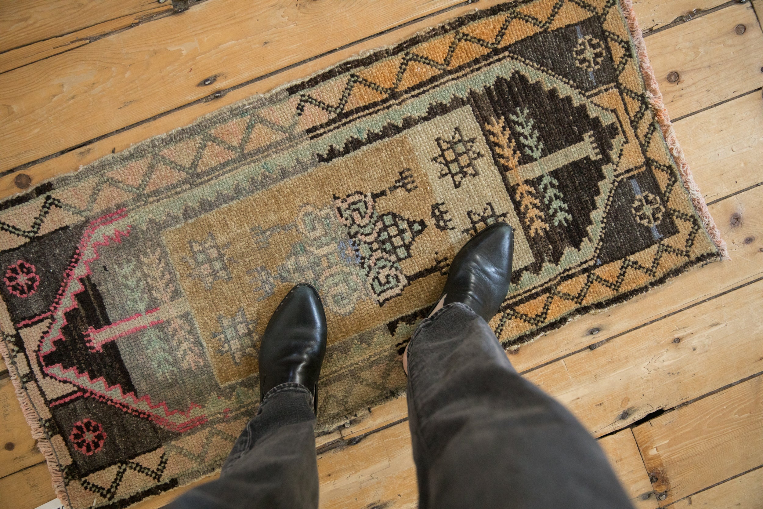 Distressed vintage Kars rug showcasing ochre, charcoal, magenta geometric and floral motifs.