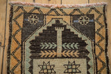 Distressed Kars rug detail: geometric finned stem and vine border in charcoal, ochre.