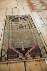 Distressed Kars rug detail: magenta finned stem motif, aged texture, and vine border.