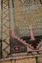 Distressed Kars rug border, geometric finned stem in magenta, seafoam, and ochre.