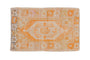 Distressed vintage Oushak rug with tangerine orange, ivory, and charcoal geometric medallion.