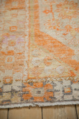 Distressed vintage Oushak rug texture with tangerine, ivory, and charcoal geometric pattern.