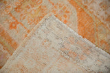 Distressed tangerine orange pile and hand-knotted foundation of a vintage Oushak rug.