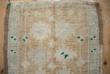 Soft hand-knotted pile of distressed Oushak rug, showing abrashed coffee, ivory, and green guls.