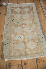 Distressed Oushak rug with abrashed ground, soft pile, in pale coffee, silver, and green.