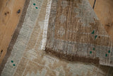 Distressed Oushak rug, showing pile wear, faint foundation, white fringe, and reverse knotting.