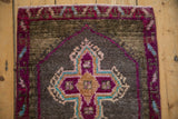 Distressed Kars rug detail: short pile, vibrant purple, blush, and teal quatrefoil design.