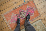 Vintage distressed Kars rug corner with terra cotta field, vibrant fuchsia geometric accents.