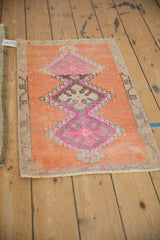 Distressed Kars rug detail: triple fuchsia and mauve geometric medallions on terra cotta, showing wear.