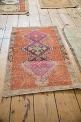 Distressed Kars rug mat with a triple geometric medallion in fuchsia, magenta, and terra cotta.