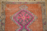 Distressed Kars rug: fuchsia geometric floral medallion detail, terra cotta field, even pile wear.