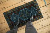 Distressed Kars rug mat with muted cobalt blue, purple, and ochre geometric patterns.
