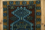 Geometric blossom motif on the vintage distressed Kars rug's ochre gold and cobalt blue border.