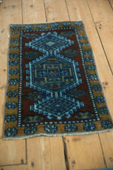 Distressed texture of a vintage Kars rug, featuring geometric border and blue medallion.