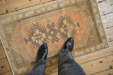 Distressed Oushak rug with muted peach and earth tones underfoot.