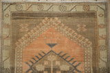 Distressed Oushak rug with abrashed sandalwood field, finned floral buds, and even pile wear.