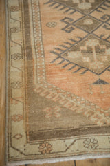 Distressed Oushak rug showing faded sandalwood field and geometric lozenge and vine patterned borders.