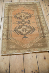 Distressed Oushak rug corner, time-softened coffee brown border, meandering motif, and beige end.