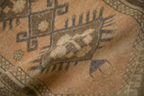 Textured detail of vintage distressed Oushak rug showing hook and geometric patterns in sandalwood and coffee.