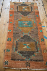 Distressed Kars rug detail: terra cotta border and turquoise starburst motifs.