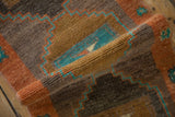 Rolled distressed Kars rug showing rich abrashed texture, primitive stepped patterns, and turquoise accents.