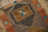 Distressed Kars rug featuring turquoise zigzag and terra cotta fields with floral pinwheel motif.