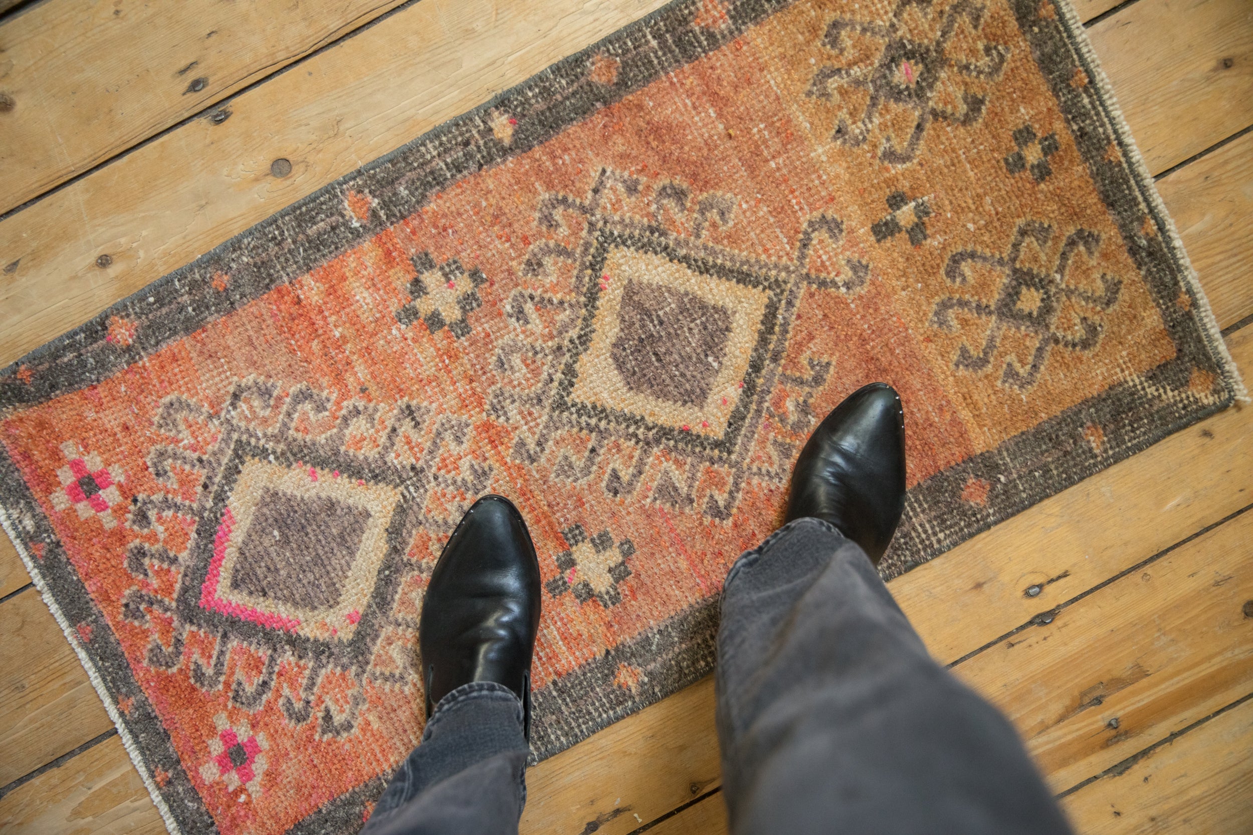 Vintage distressed Kars rug displaying double hook medallions, terra cotta, and even pile wear.