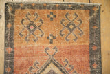 Distressed vintage Kars rug top corner, featuring textured pile, abrashed sandalwood and terra cotta.