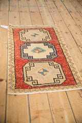 Distressed Kars rug mat's geometric medallion with pinwheel floral and lightning contour border.
