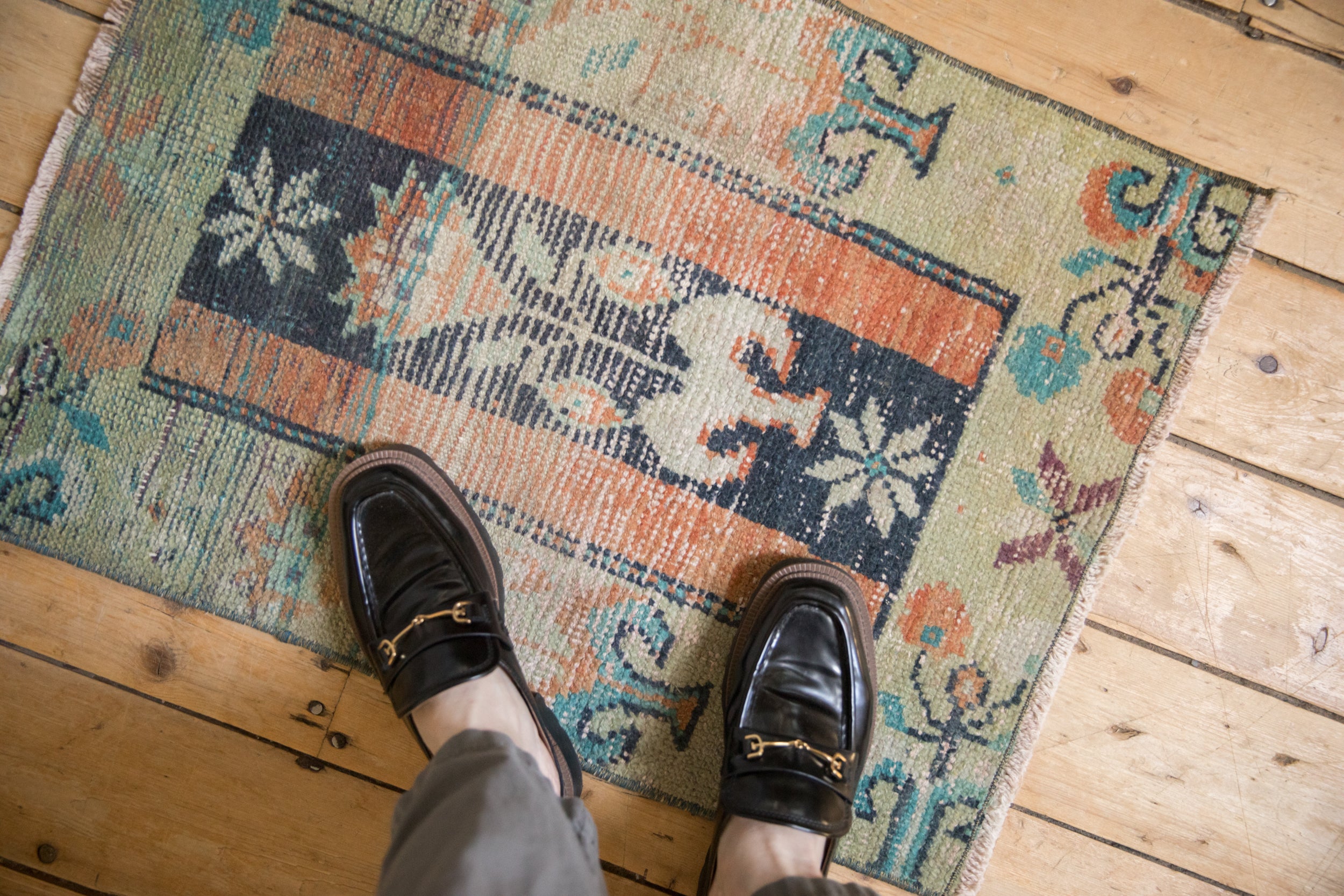 Vintage distressed Anatolian rug, worn pile revealing cobalt blue and terra cotta motifs.