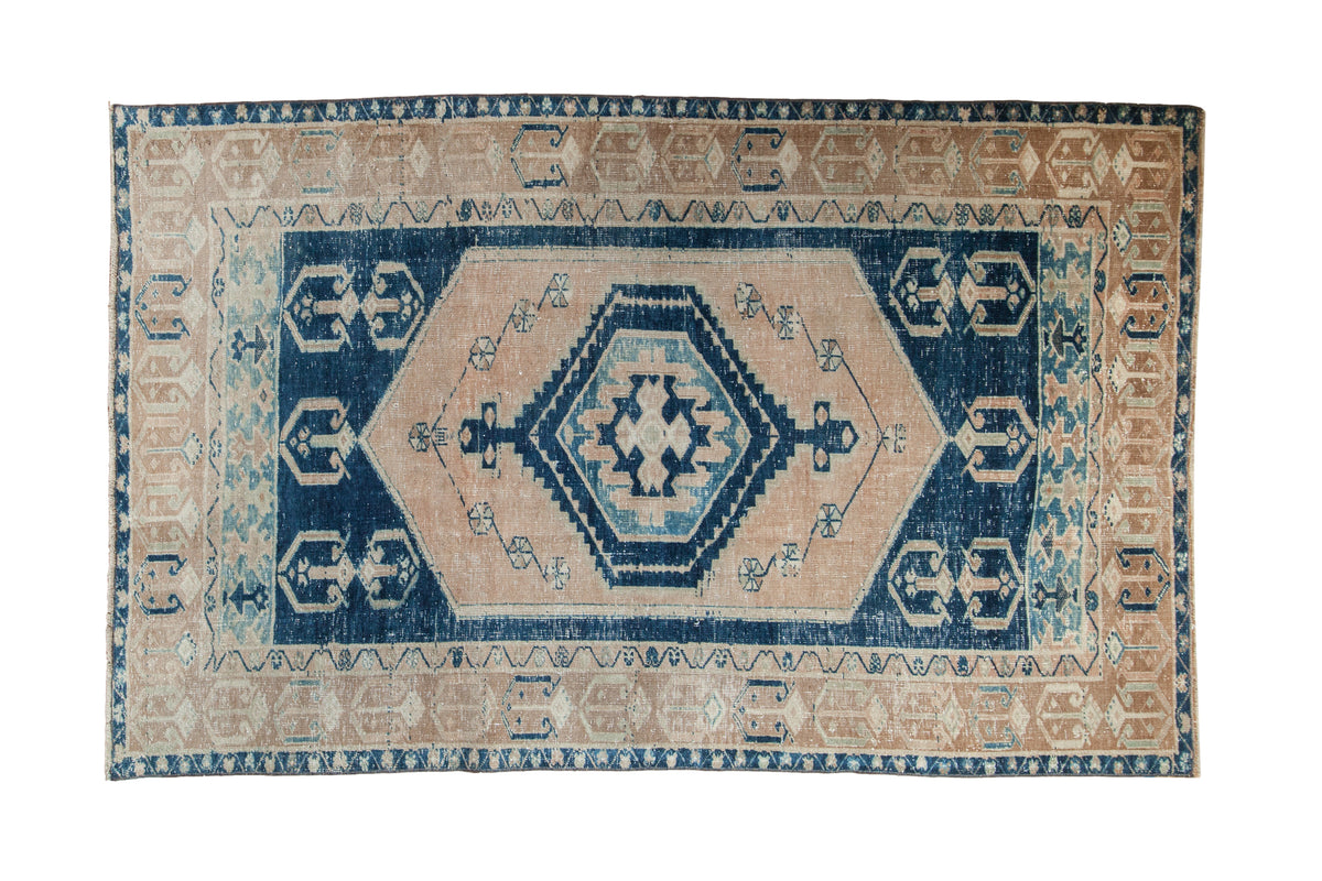 Distressed Oushak rug with cobalt blue hexagonal medallion, antique ivory field, geometric borders, 4'6" x 7'1".